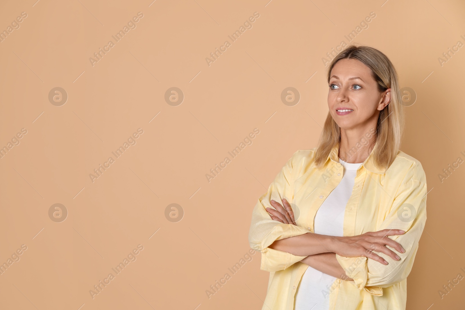 Photo of Beautiful smiling woman on beige background, space for text