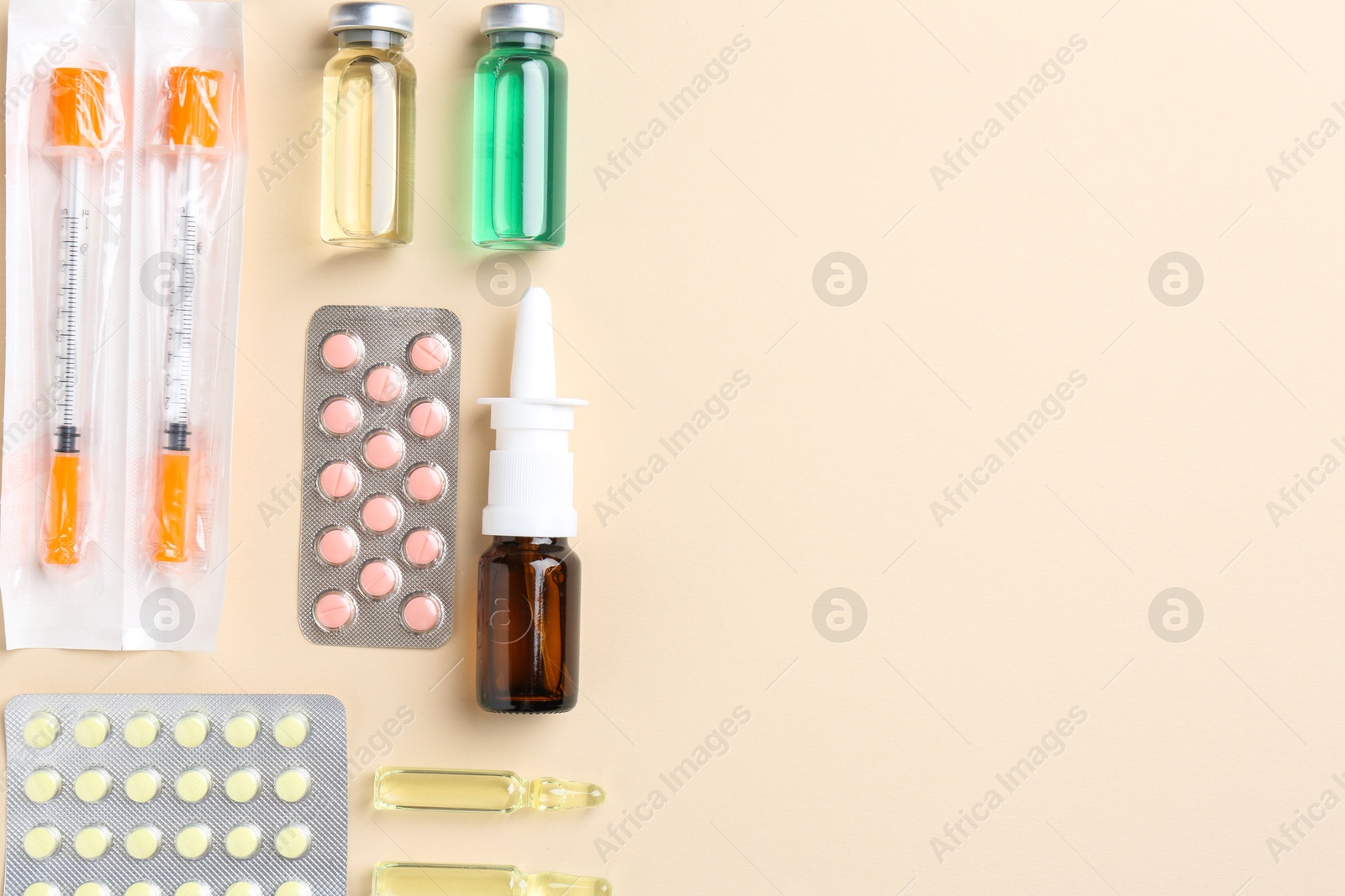 Photo of Pharmacist concept. Flat lay composition with vials, syringes and pills on beige background, space for text