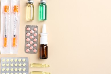 Pharmacist concept. Flat lay composition with vials, syringes and pills on beige background, space for text