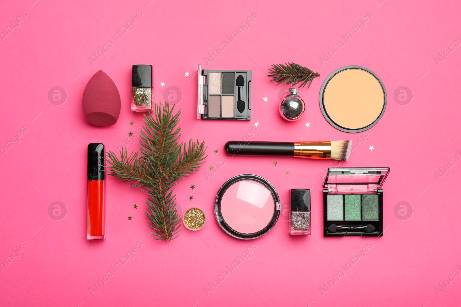 Photo of Flat lay composition with makeup products and Christmas decor on pink background