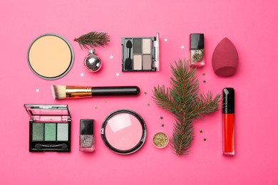 Photo of Flat lay composition with makeup products and Christmas decor on pink background