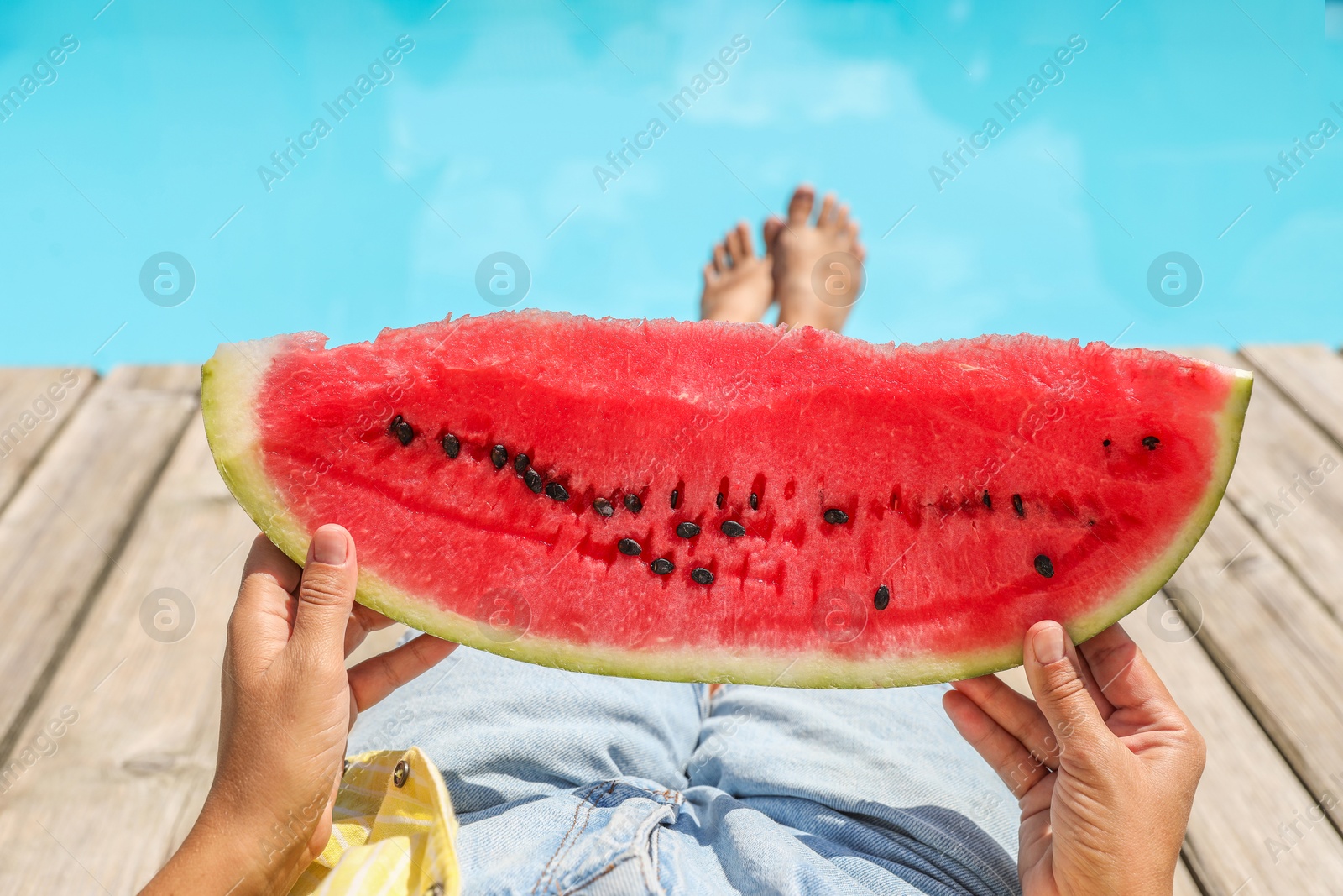 Photo of Woman with slice of juicy watermelon near swimming pool outdoors, closeup