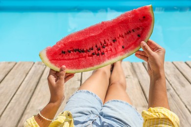 Woman with slice of juicy watermelon near swimming pool outdoors, closeup