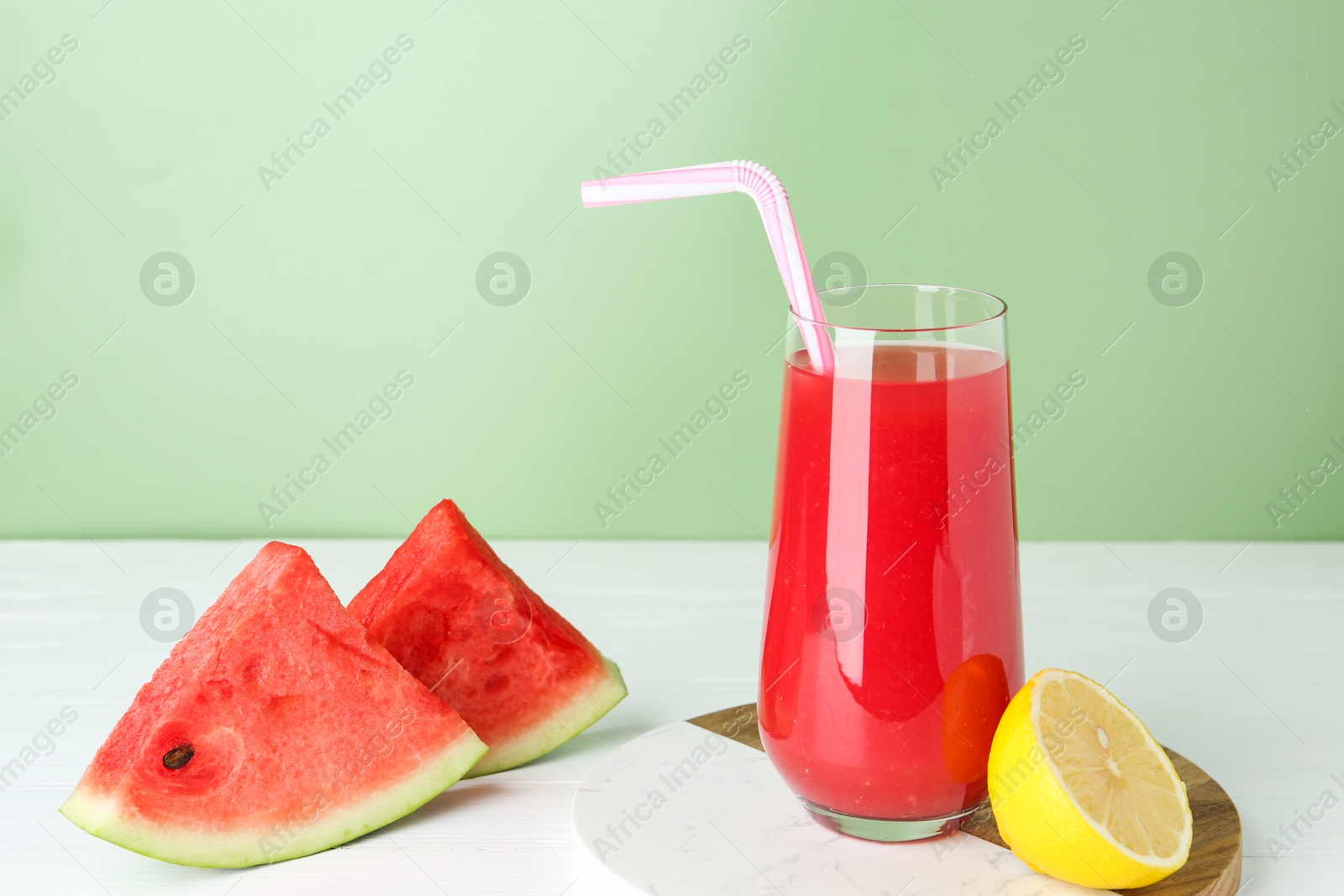 Photo of Tasty watermelon drink in glass and fresh fruits on white wooden table