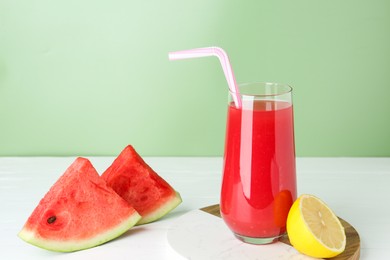 Photo of Tasty watermelon drink in glass and fresh fruits on white wooden table