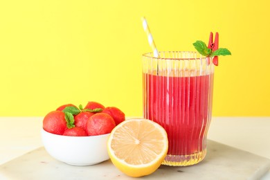 Photo of Tasty watermelon drink in glass and fresh fruits on white table, closeup