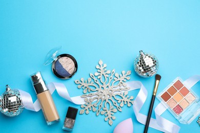 Photo of Flat lay composition with makeup products and Christmas decor on light blue background. Space for text