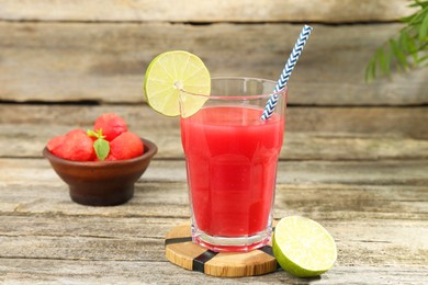 Photo of Tasty watermelon drink in glass and fresh fruits on wooden table