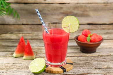 Photo of Tasty watermelon drink in glass and fresh fruits on wooden table