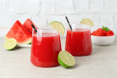 Photo of Delicious watermelon drink in glasses and fresh fruits on light table