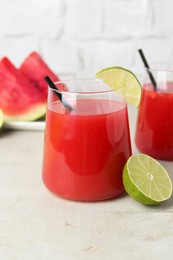 Photo of Delicious watermelon drink in glasses and fresh fruits on light table