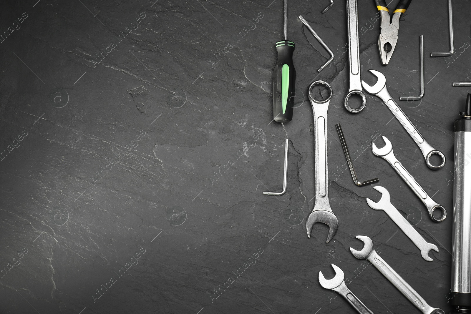 Photo of Parts of bicycle and tools on black table, flat lay. Space for text