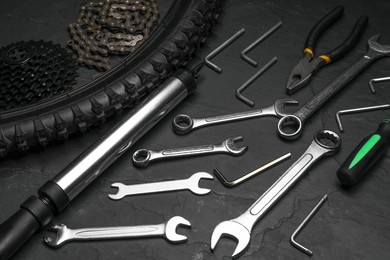 Parts of bicycle and tools on black table