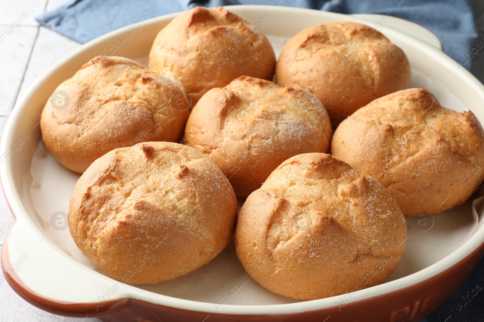 Photo of Baking dish with homemade tasty buns on table, closeup