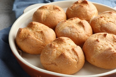 Photo of Baking dish with homemade tasty buns on table, closeup