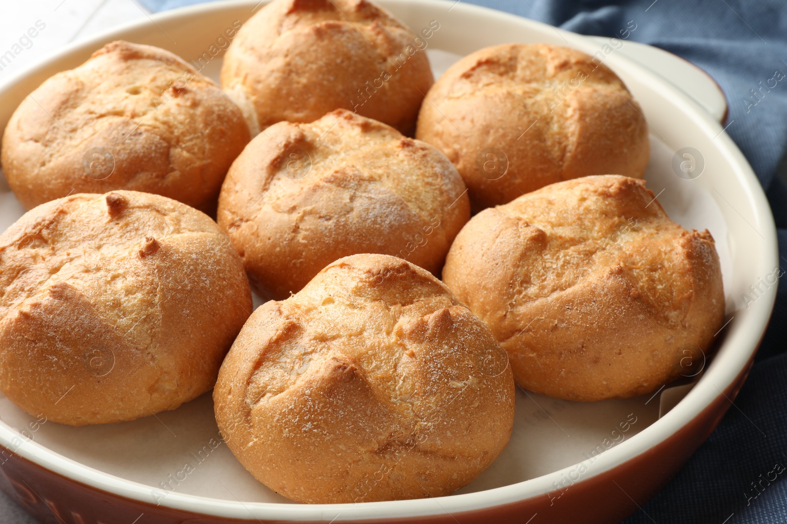 Photo of Baking dish with homemade tasty buns on table, closeup