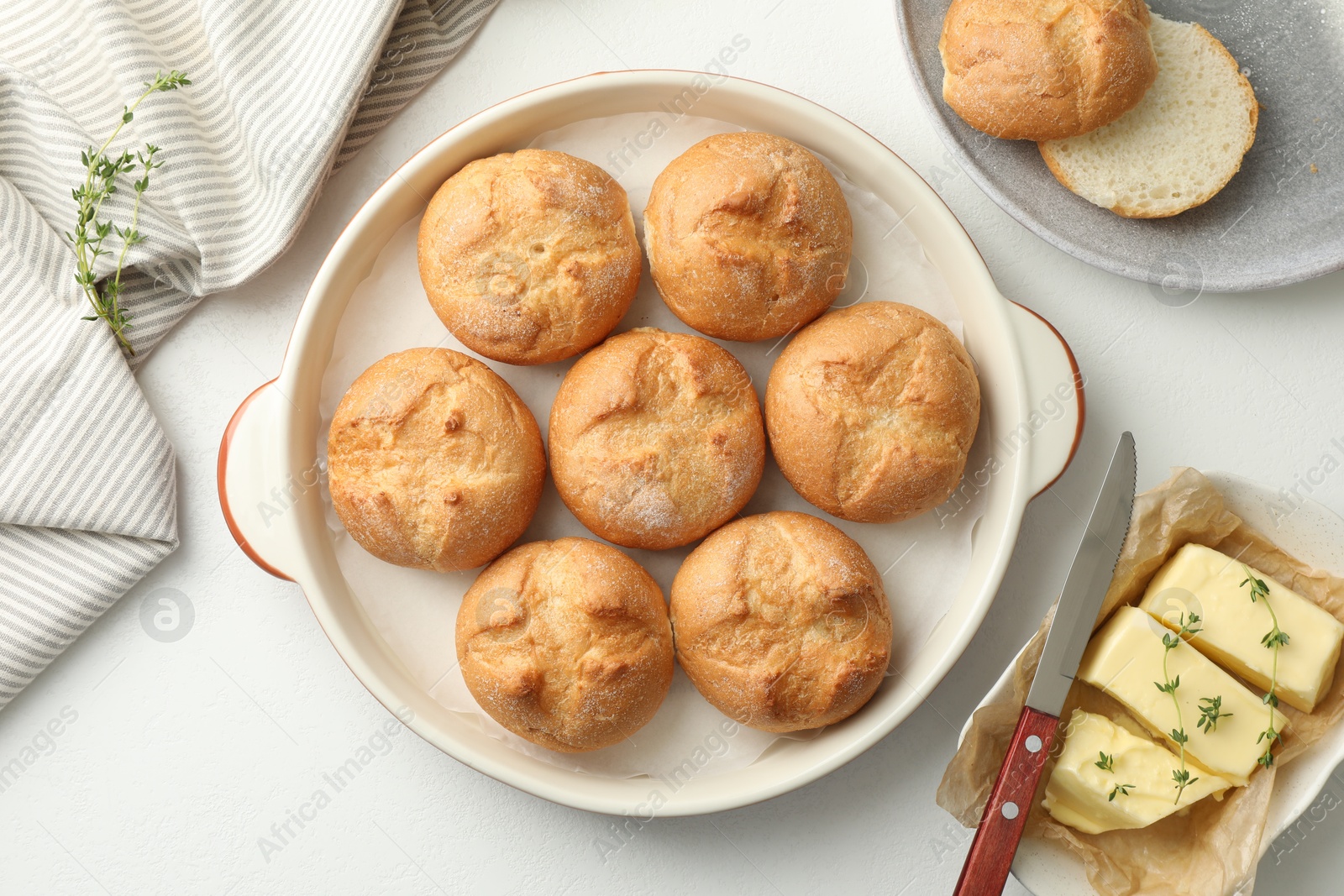 Photo of Flat lay composition with homemade tasty buns and butter on white table