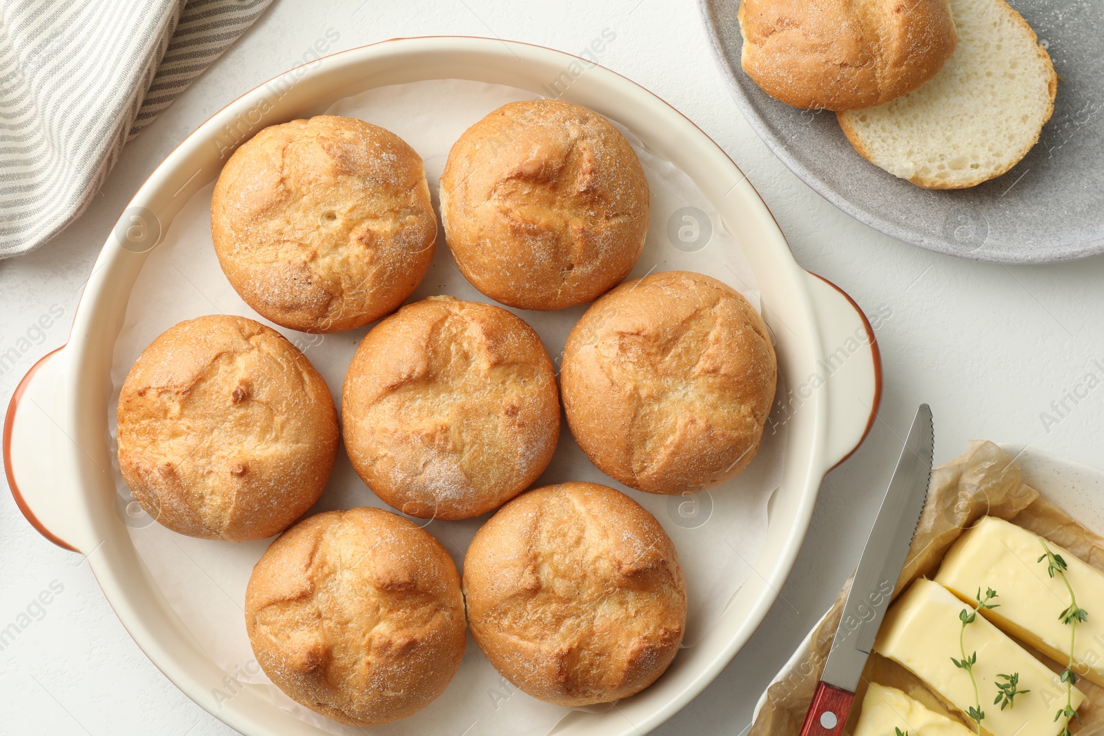 Photo of Flat lay composition with homemade tasty buns and butter on white table