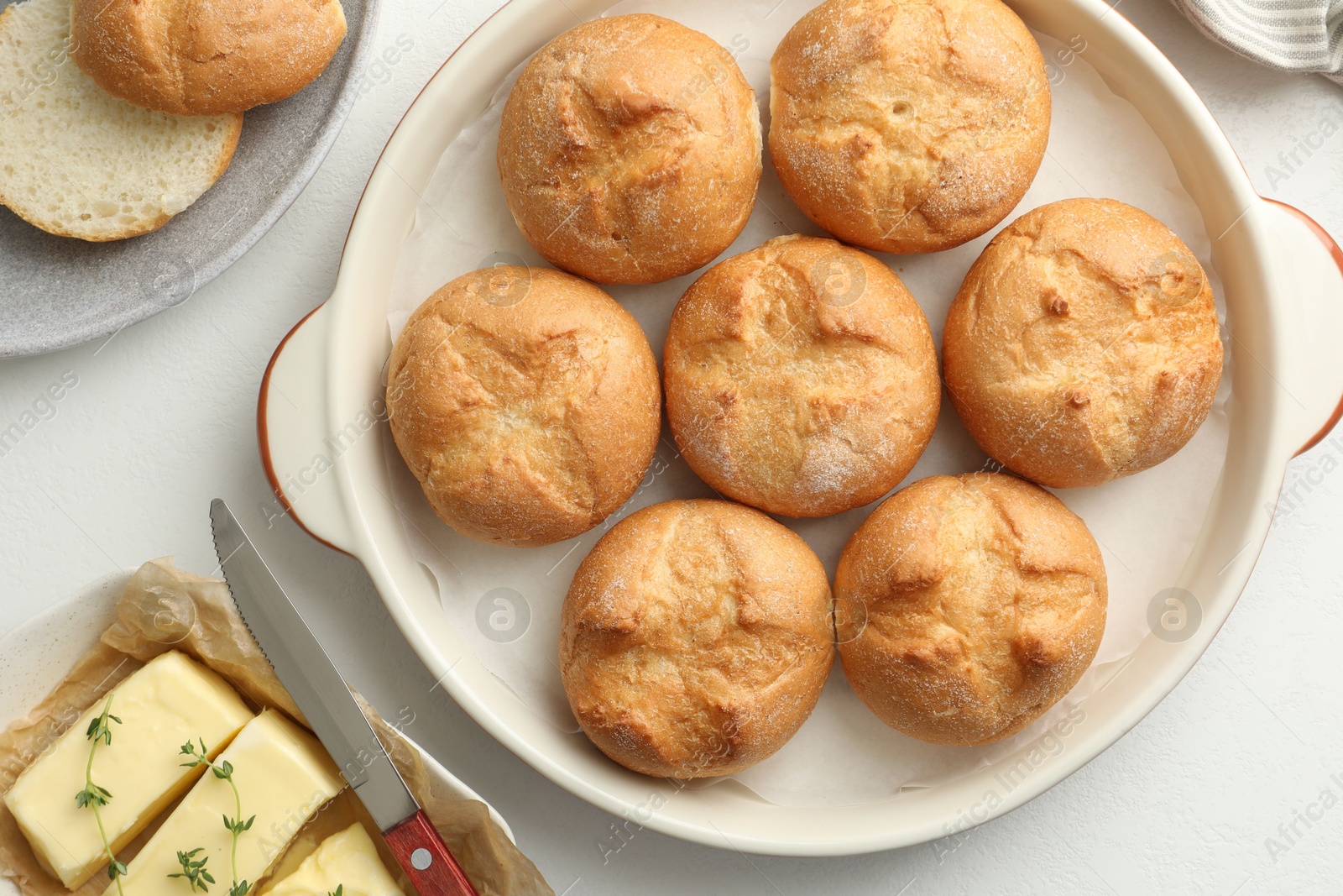 Photo of Flat lay composition with homemade tasty buns and butter on white table