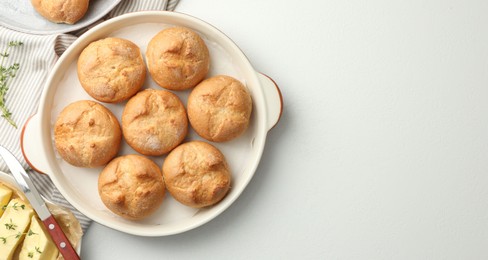 Flat lay composition with homemade tasty buns and butter on white table. Space for text