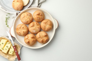 Flat lay composition with homemade tasty buns and butter on white table. Space for text