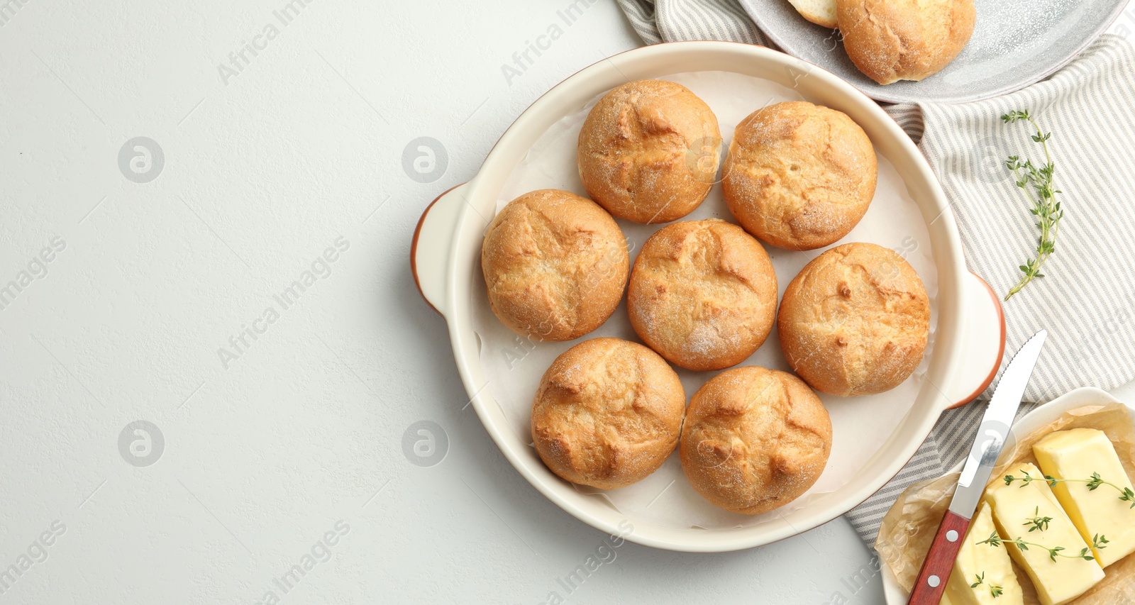 Photo of Flat lay composition with homemade tasty buns and butter on white table. Space for text