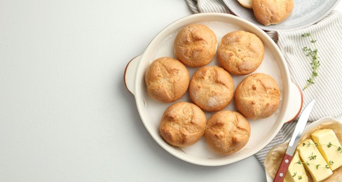 Photo of Flat lay composition with homemade tasty buns and butter on white table. Space for text