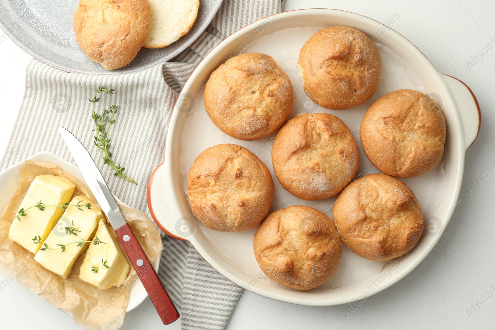 Photo of Flat lay composition with homemade tasty buns and butter on white table