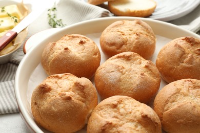 Baking dish with homemade tasty buns on table, closeup