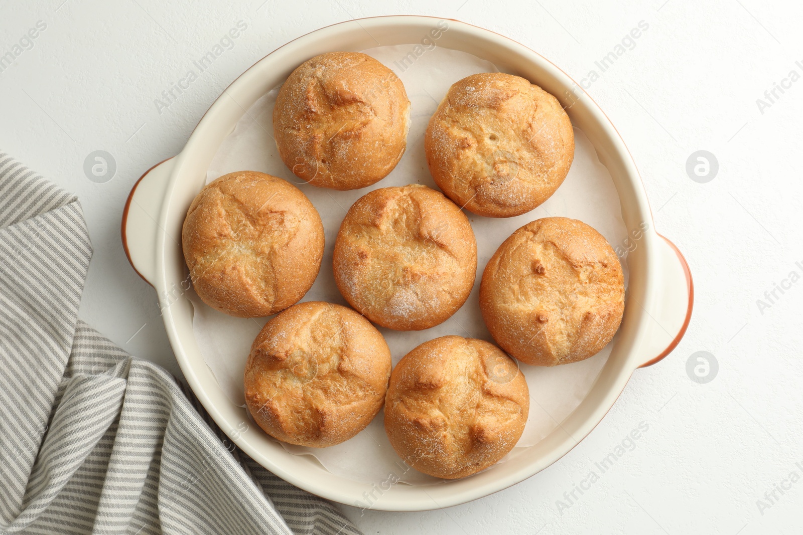 Photo of Baking dish with homemade tasty buns on white table, top view