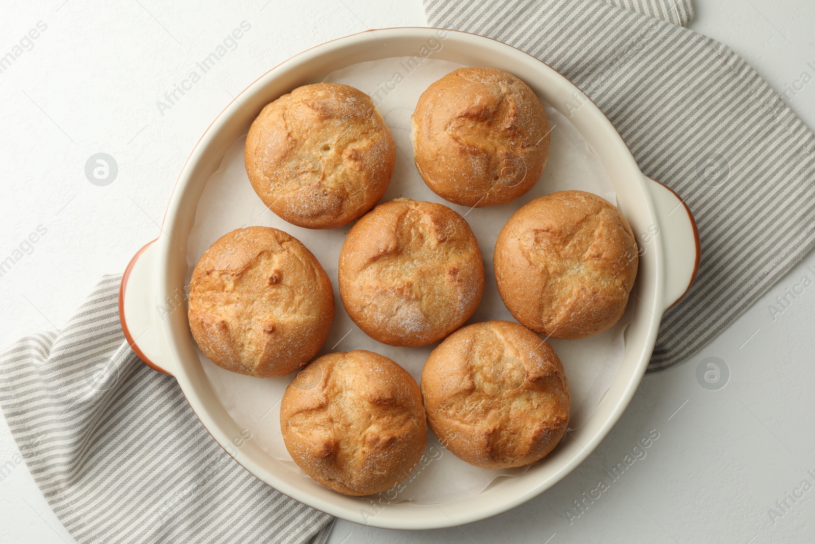 Photo of Baking dish with homemade tasty buns on white table, top view