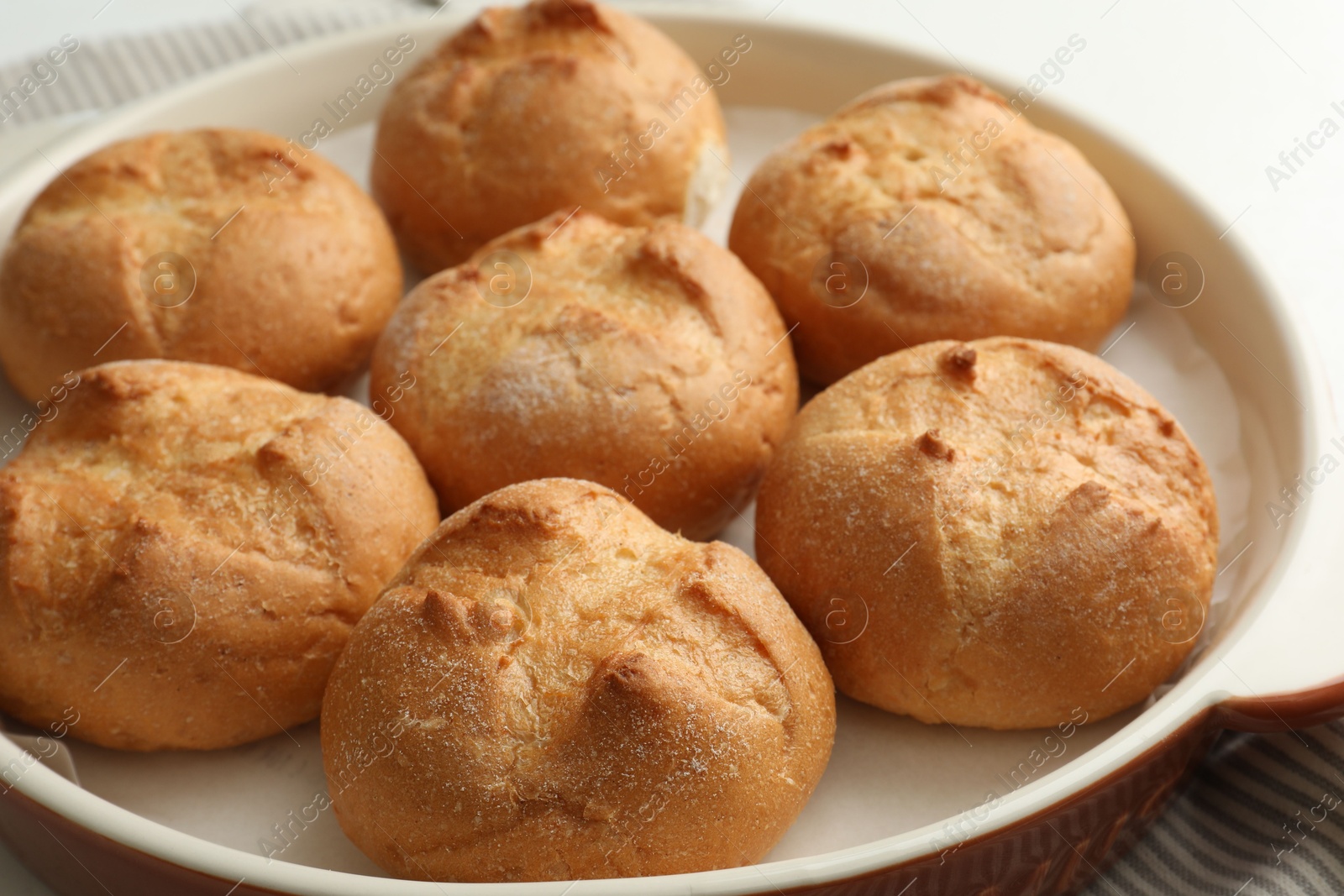 Photo of Baking dish with homemade tasty buns on table, closeup