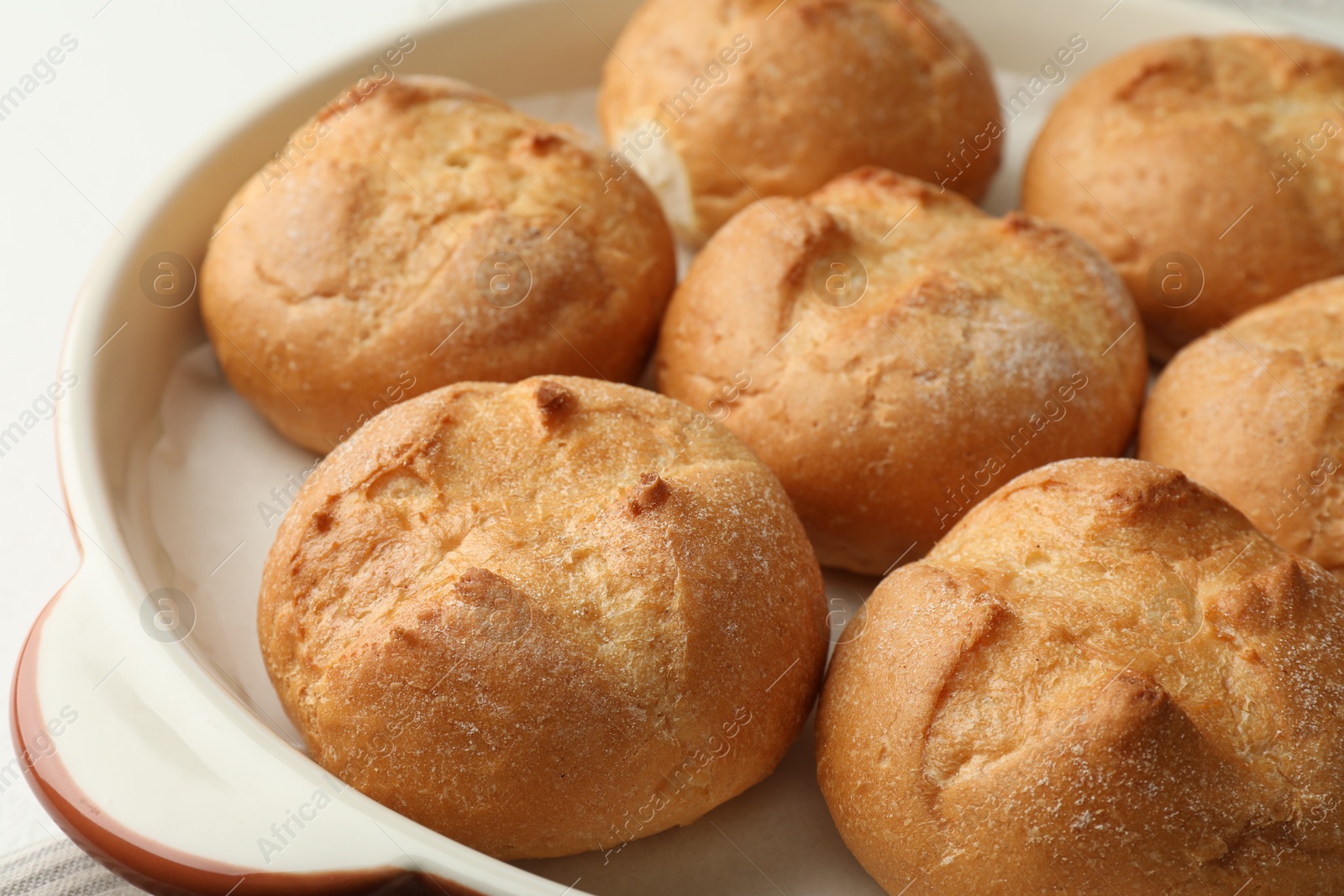 Photo of Baking dish with homemade tasty buns on table, closeup