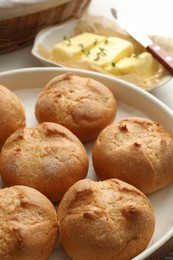 Photo of Baking dish with homemade tasty buns on table, closeup