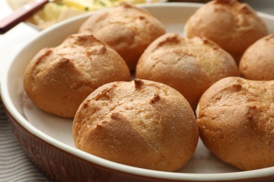 Photo of Baking dish with homemade tasty buns on table, closeup