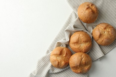 Photo of Homemade tasty buns on white table, top view. Space for text