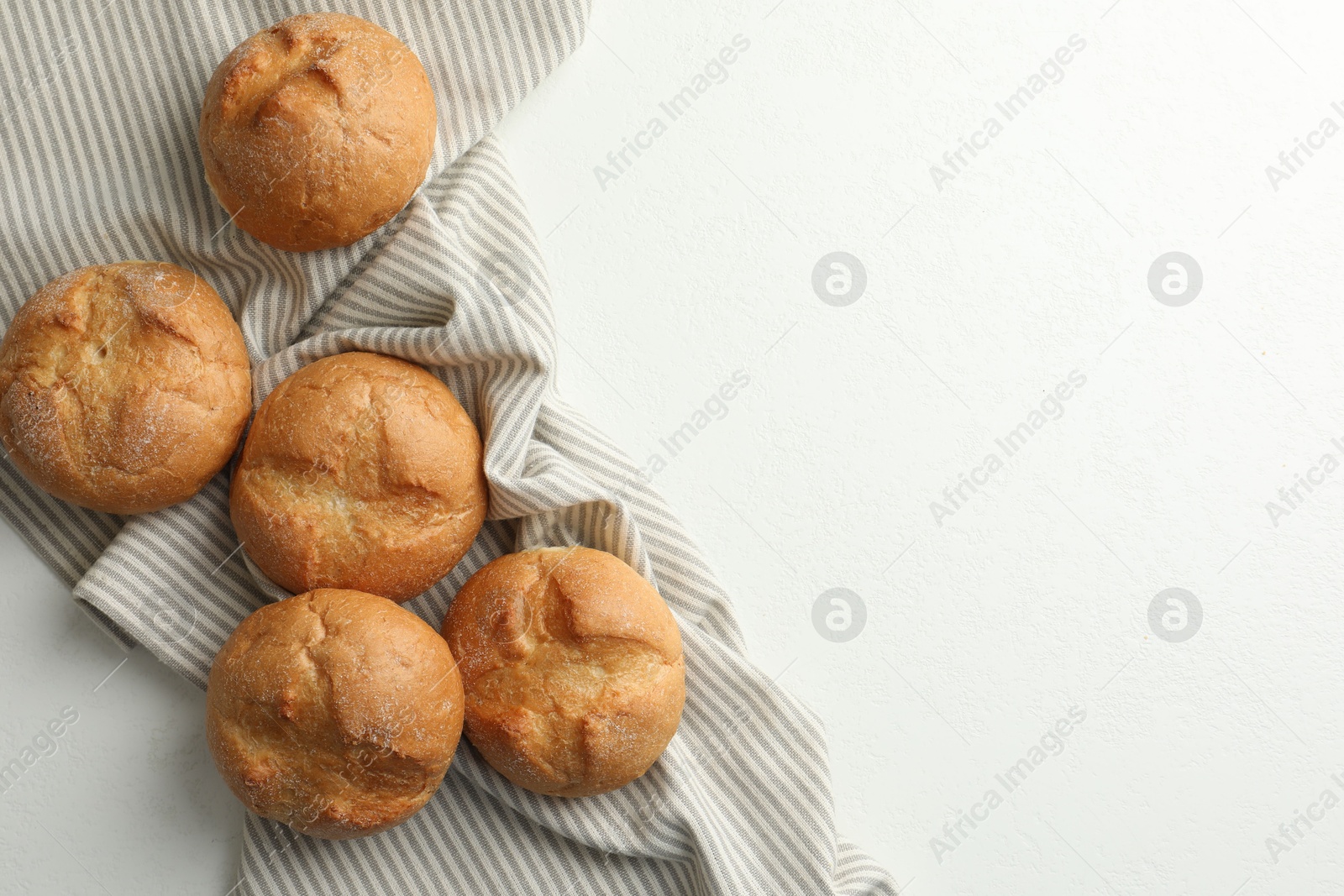 Photo of Homemade tasty buns on light table, top view. Space for text