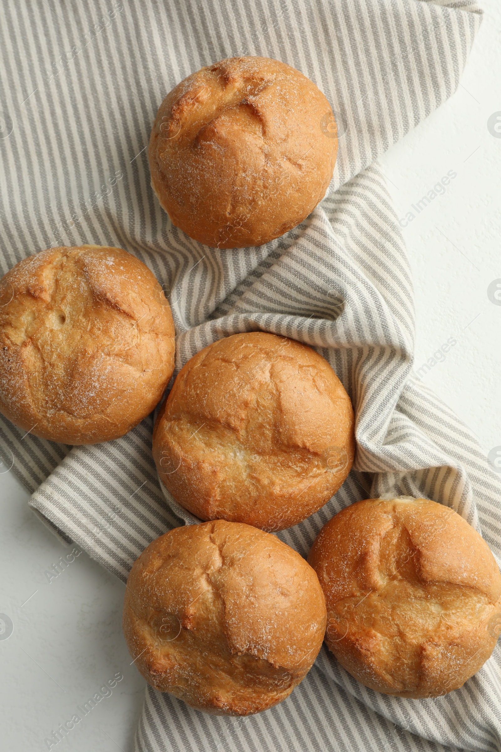 Photo of Homemade tasty buns on light table, top view