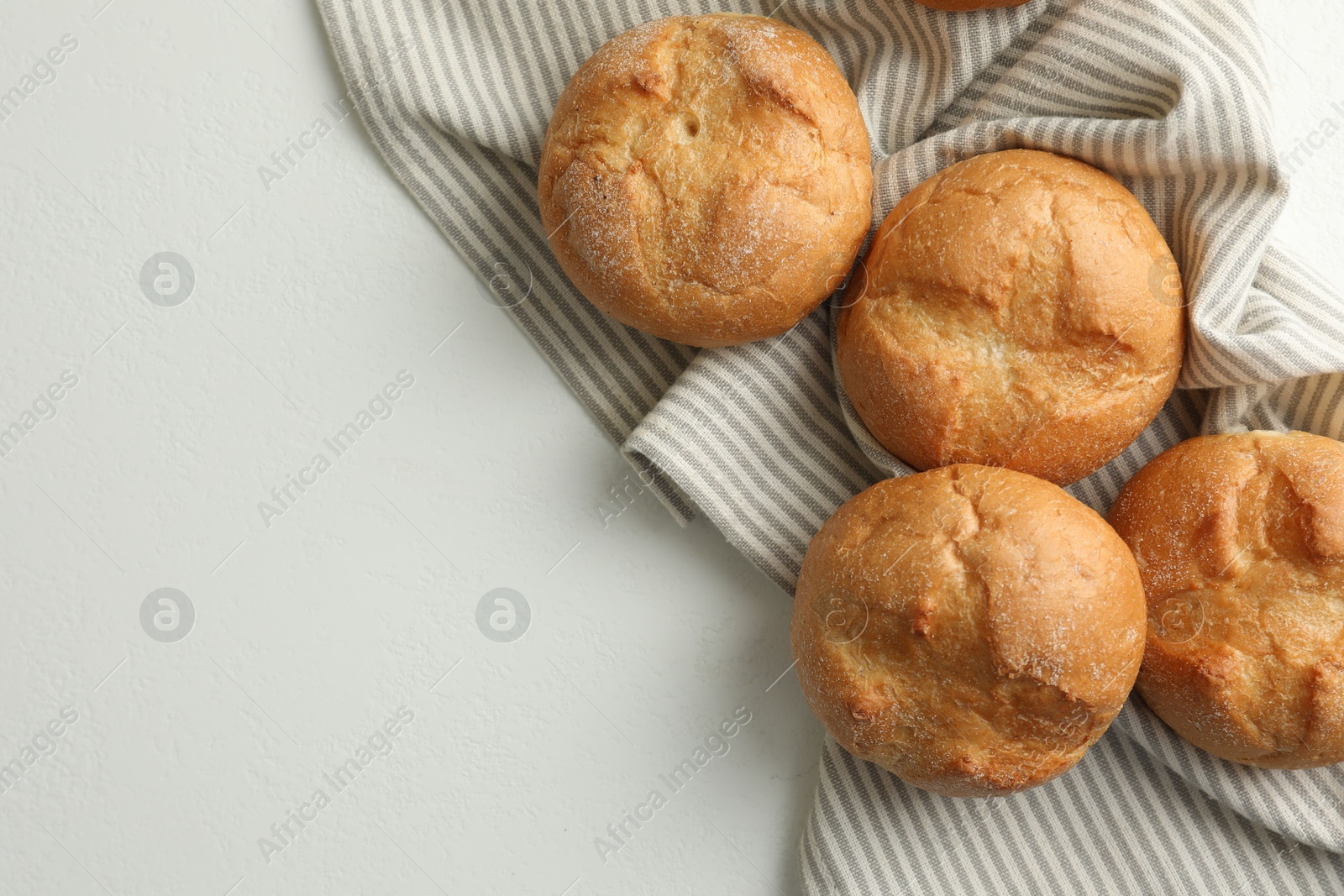 Photo of Homemade tasty buns on light table, top view. Space for text