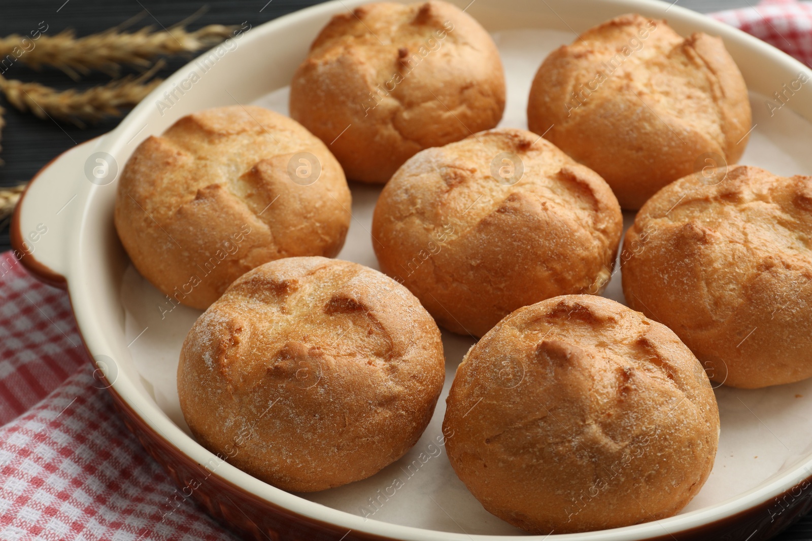 Photo of Baking dish with homemade tasty buns on table, closeup