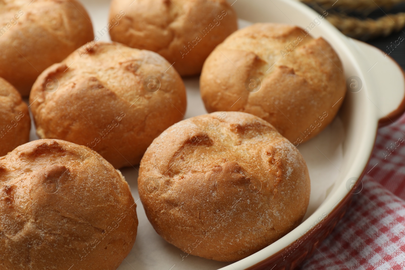 Photo of Baking dish with homemade tasty buns on table, closeup