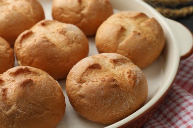 Photo of Baking dish with homemade tasty buns on table, closeup