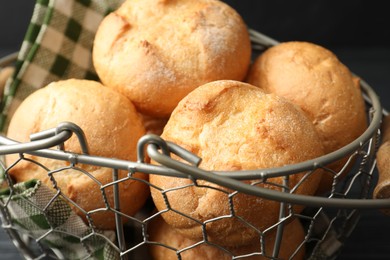 Photo of Homemade tasty buns in metal basket, closeup