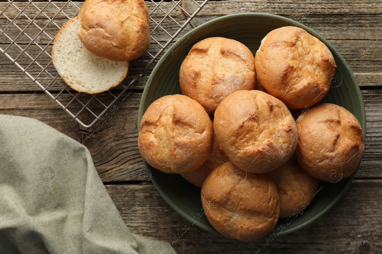 Photo of Homemade tasty buns on wooden table, flat lay