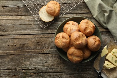 Photo of Homemade tasty buns, butter and knife on wooden table, flat lay. Space for text