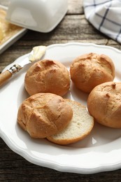 Photo of Plate with homemade tasty buns on table, closeup