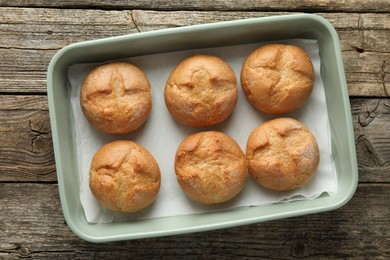 Homemade tasty buns in baking dish on wooden table, top view