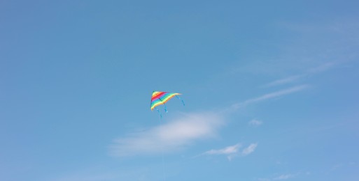 One colorful kite flying in blue sky