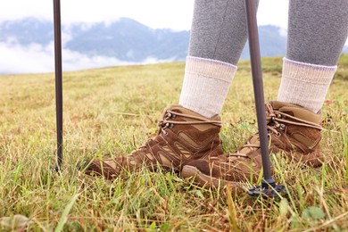 Photo of Young hiker with trekking poles outdoors, closeup