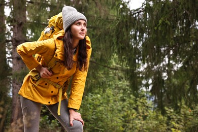 Photo of Young hiker with backpack in forest, space for text